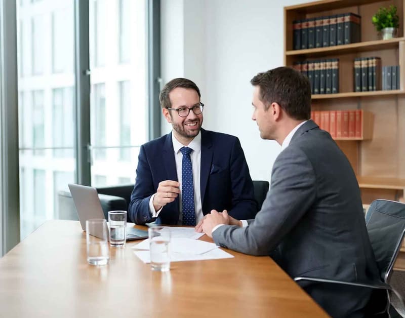 Steuerberater Sebastian Schäfer im Gespräch mit einem Mandanten am Besprechungstisch